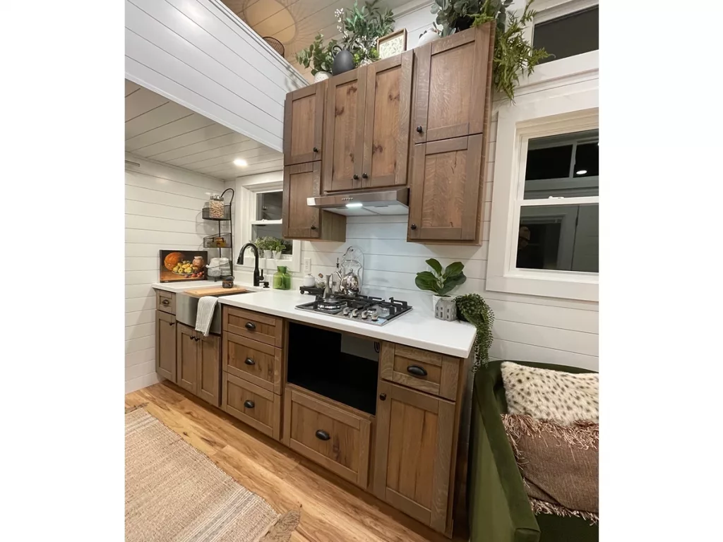 Kitchen showing cabinets, stovetop and sink.