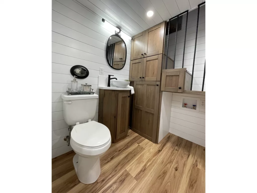 Bathroom showing stairs leading to loft with storage areas in stairs