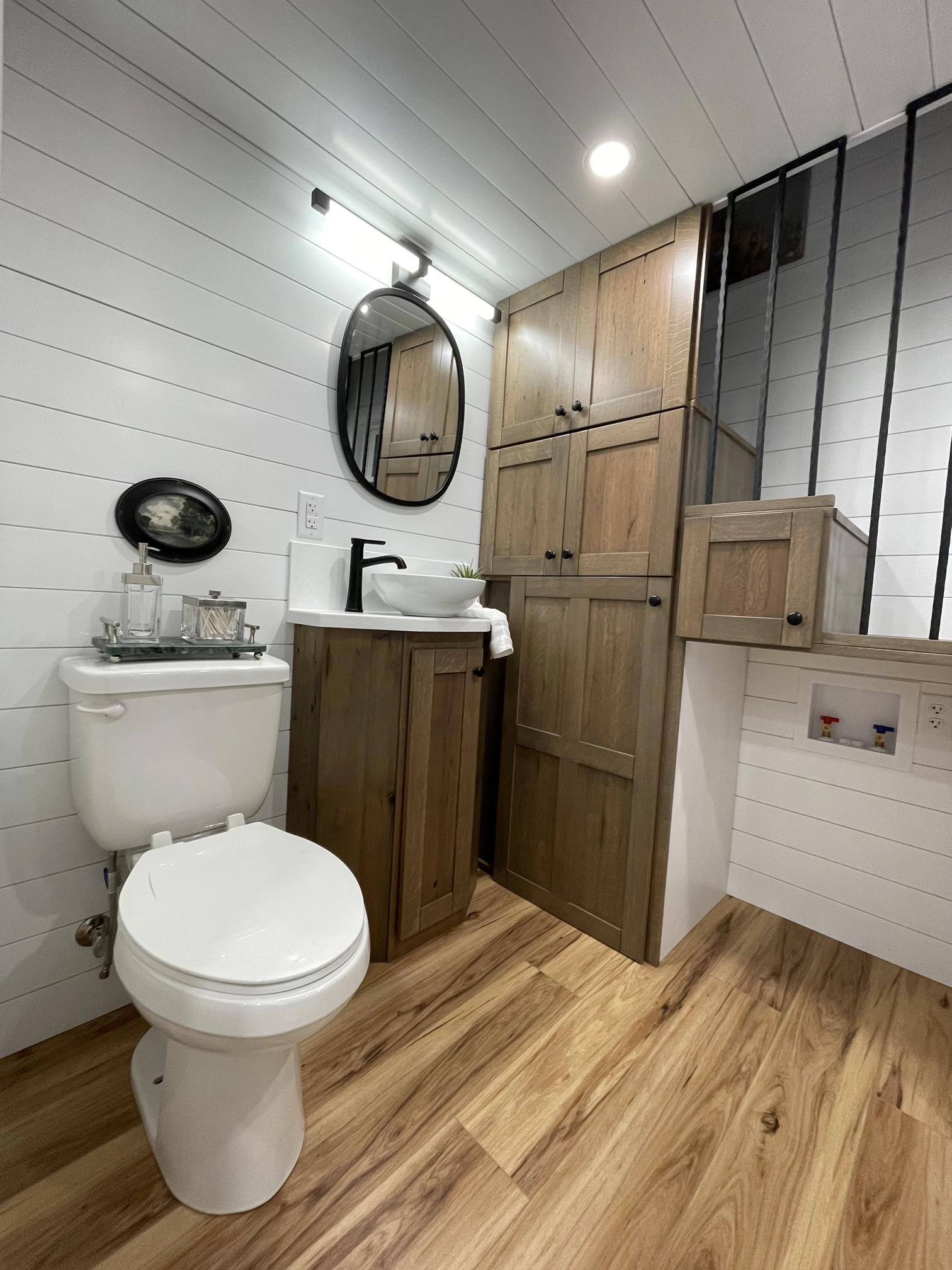 Bath area showing commode and storage under stairs to loft.